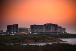 a city skyline at sunset with a building at Radisson Blu Hotel, Abu Dhabi Yas Island in Abu Dhabi