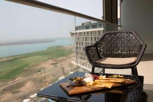 a table with a tray of food and a chair on top of a building at Radisson Blu Hotel, Abu Dhabi Yas Island in Abu Dhabi +37 photos