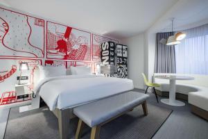 a bedroom with a large bed and a desk at Radisson RED Brussels in Brussels