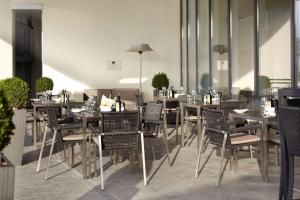 a restaurant with tables and chairs in a room at Radisson Blu Hotel, Hamburg Airport in Hamburg
