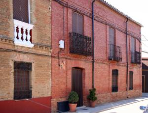 un ancien bâtiment en briques rouges avec des fenêtres à barreaux noirs dans l'établissement La Pequeña A y B, à Villaherreros