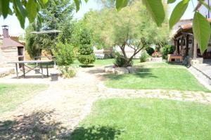 a garden with a picnic table and a bench at La Pequeña A y B in Villaherreros
