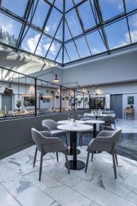 un ristorante con tavoli e sedie e un soffitto in vetro di Radisson Blu Scandinavia Hotel Aarhus a Arhus