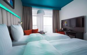 a hotel room with two beds and a television at Park Inn by Radisson Riga Valdemara in Rīga