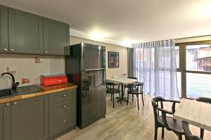 a kitchen with a refrigerator and a table with chairs at Sakhli at Chavchavadze ave 15 in Tbilisi City