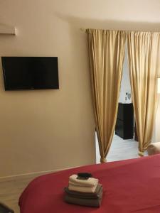 Schlafzimmer mit einem Bett und einem TV an der Wand in der Unterkunft San Siro Suite fiera in Mailand