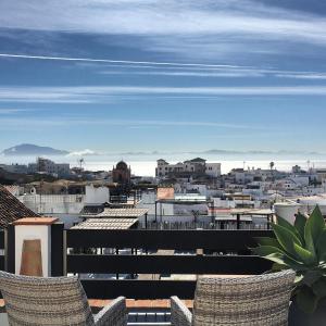 a view of a city from a balcony with chairs at Darcilla Guest House in Tarifa