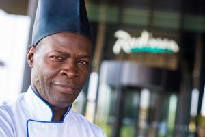 Ein Mann mit einem Abschlusshut vor einem Gebäude. in der Unterkunft Radisson Hotel Dakar Diamniadio in Dakar + 148 Fotos