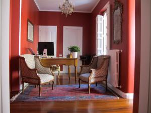 an office with red walls and a desk with chairs at Relais Teatro Argentina in Rome