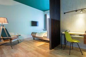 a bedroom with a bed and a desk and a chair at Park Inn By Radisson Brussels Airport in Diegem