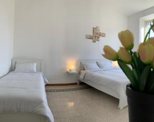 una camera con due letti e un vaso di fiori di Chiaretta Guest House a Roma