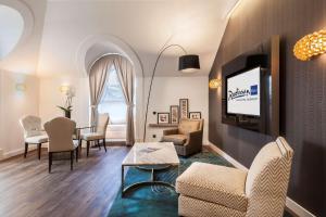 a living room with a couch and a tv and a table at Radisson Blu Béke Hotel, Budapest in Budapest