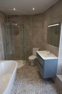 a bathroom with a tub and a sink and a toilet at La Bicyclette Bleue in Montmorillon