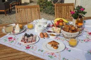 a table topped with plates of food and fruit at La Bicyclette Bleue in Montmorillon