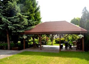 a pavilion with a table and chairs in a garden at Pokoje Kalisz in Kalisz