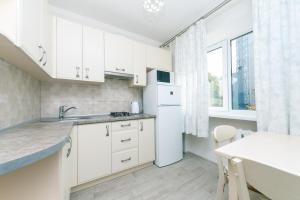 uma cozinha com armários brancos e um frigorífico branco em New apartment on Starokyivska 1/5 em Kiev