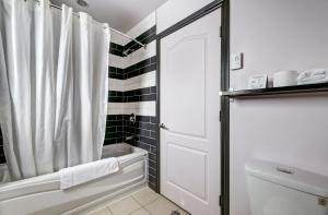 a bathroom with a shower with a white shower curtain at Auberge St. Jacques in Montreal
