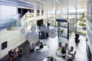 a lobby with chairs and tables in a building at Radisson Blu New Providence Wharf Hotel, London in London