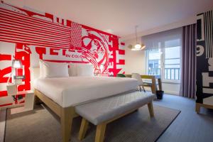 um quarto com uma cama com uma parede vermelha em Radisson RED Brussels em Bruxelas