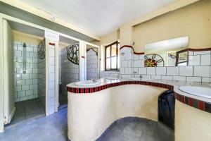 a large bathroom with two sinks and two mirrors at La Clairière du Verbamont in Claudon