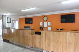 a waiting room with wooden counters and a clock on the wall at Hotel Flamingo Irapuato in Irapuato