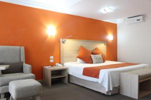 una stanza d'albergo con un letto e una sedia di Hotel Flamingo Irapuato a Irapuato
