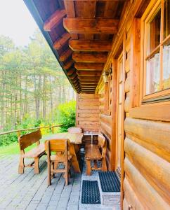 un portico di una cabina con tavolo e sedie di Drevenica Jánošík a Terchová