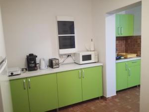 een keuken met groene kasten en een magnetron bij Boncz Udvar in Praid