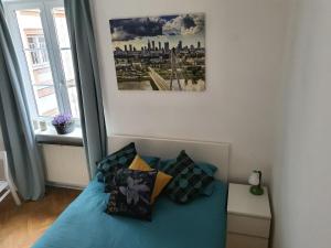 Un dormitorio con una cama azul con almohadas. en RentOnline Kościelna Apartment Old Town, en Varsovia