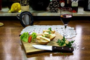 un verre de vin, une assiette de nourriture et un couteau dans l'établissement Gasthaus & Hotel Drei Lilien, à Werbach