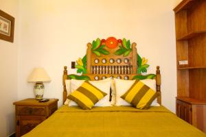 a bedroom with a bed with a flower headboard at El Molino de Allende Guest House in San Miguel de Allende