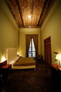 ナポリにあるLe Stanze Del Vicerè Boutique Hotelの格天井のベッドルーム1室(ベッド1台付)