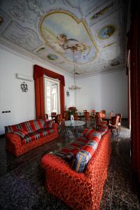 un soggiorno con divani, tavolo e soffitto di Le Stanze Del Vicerè Boutique Hotel a Napoli
