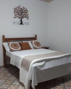 a bedroom with a bed with a tree on the wall at Pousada Mirante Imperial in Tiradentes