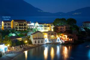 a town at night with lights on the water w obiekcie Gardenia House w mieście Asos