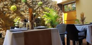 a dining room with two tables and a stone wall at MH Boutique Hotel in San Pedro Sula