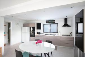 a white kitchen with a white table and chairs at Dream Villa Lorient 604 in Saint Barthelemy