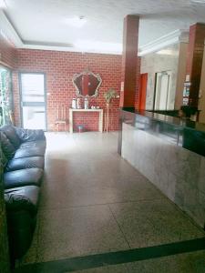 uma sala de estar com um sofá de couro preto num quarto em Goias Hotel em Goiânia