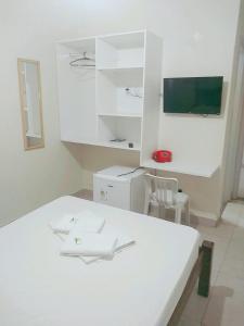 a kitchen with a white table and white cabinets at Goias Hotel in Goiânia
