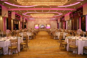 a banquet hall with white tables and chairs at The Diplomat Radisson Blu Hotel Residence & Spa in Manama
