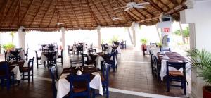 a dining room with tables and chairs in a restaurant at Rento departamento frente a la playa in Manzanillo