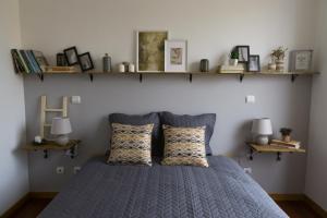 Un dormitorio con una cama azul con estanterías en la pared en Avenida Central - Coimbra Accommodation en Coimbra