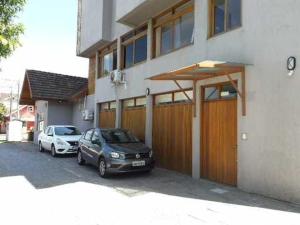 two cars parked in front of a house at Novo Aconchego in Gramado