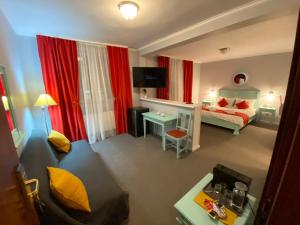 a hotel room with a bed and a desk at Vila De Argint Aleea Pelesului Nr 2 in Sinaia