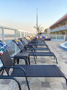 szereg ławek siedzących obok plaży w obiekcie Sandals Inn w mieście Daytona Beach