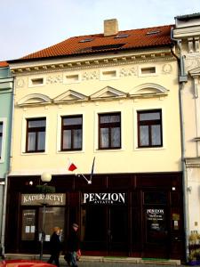 a building with people walking in front of it at Penzion Aviatik in Čáslav