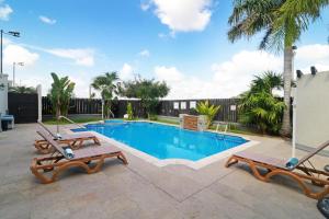 een zwembad met 2 ligstoelen naast bij Holiday Inn Reynosa Industrial Poniente, an IHG Hotel in Reynosa