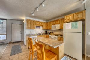 狄龍的住宿－Orfino 311，厨房配有木制橱柜和白色冰箱。