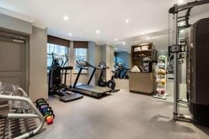 una palestra con tapis roulant e attrezzature per il fitness in una sala di Radisson Blu Edwardian Vanderbilt Hotel, London a Londra