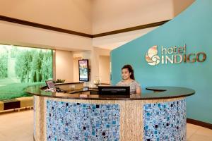 a woman standing at a hotel lobby at Hotel Indigo Chicago - Vernon Hills by IHG in Vernon Hills